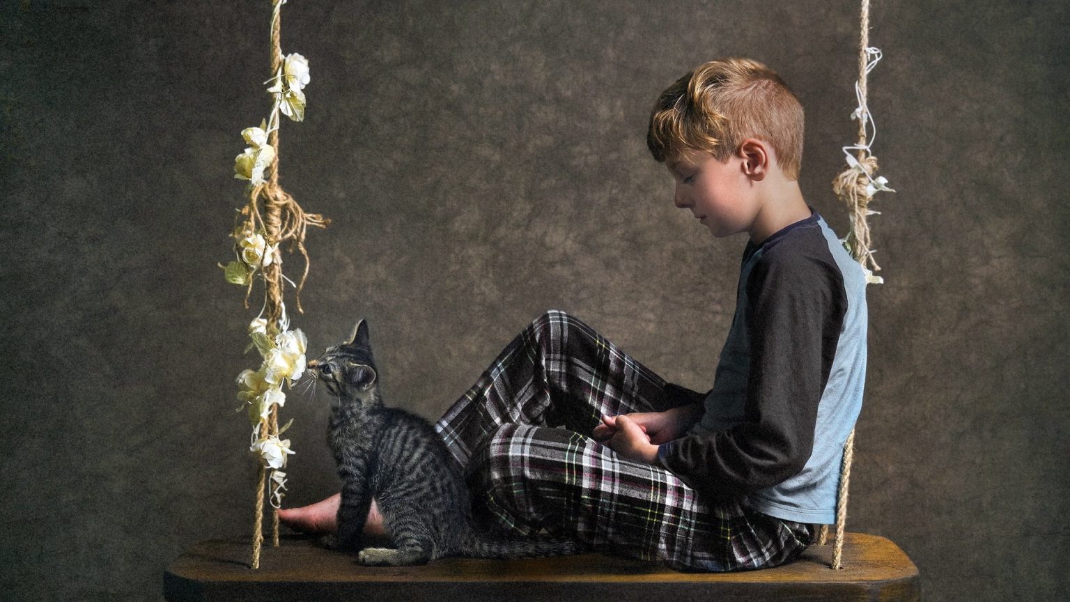 Fond d’écran gratuit: Un garçon assis sur une balançoire avec un chat
